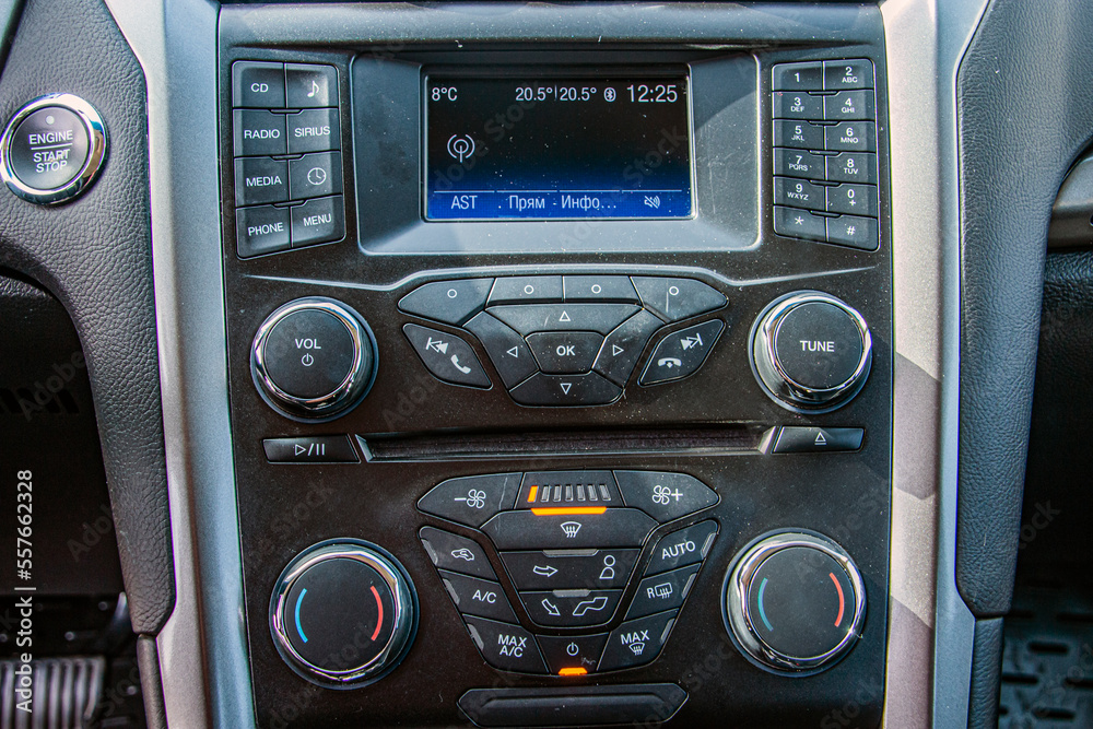 Radio in the car with many toggle switches and buttons	
