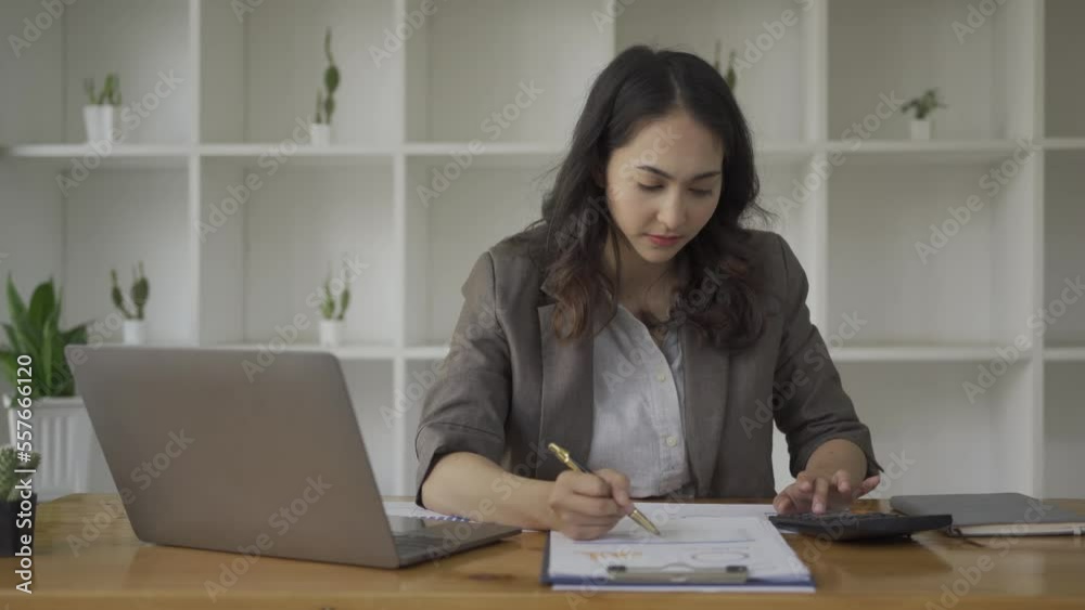 Businesswoman looking at paper, charts, graphs and calculating financial expenses with statistics and calculator, girl working at office, financial analysis while working on laptop Businesswoman looking at paper, charts, graphs and calculating financial expenses with statistics and calculator, girl working at office, financial analysis while working on laptop