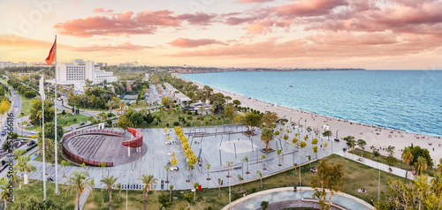 Fototapeta Naklejka Na Ścianę i Meble -  Aerial view of a beach park with Turkish flag and resting people in Antalya, Turkiye. Mediterranean sea coast and riviera.