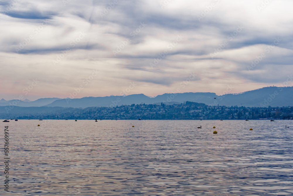 Scenic view over Lake Zürich with Swiss Alps in the background on a blue cloudy autumn day. Photo taken October 30th, 2022, Zurich, Switzerland.