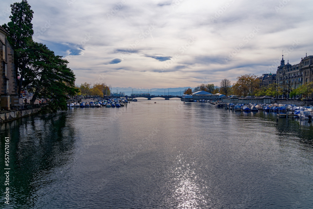 Beautiful scenic view of Limmat River, Quay Bridge, Lake Zürich and Swiss Alps seen from the old town of Zürich on a blue cloudy autumn day. Photo taken October 30th, 2022, Zurich, Switzerland.