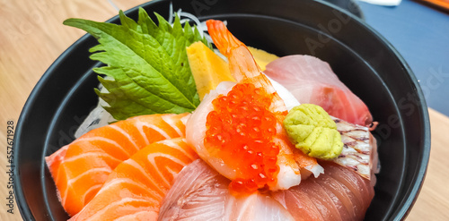 Raw fish in Japanese style, Sashimi, in black bowl, tuna, salmon, snapper, egg, served with wasabi