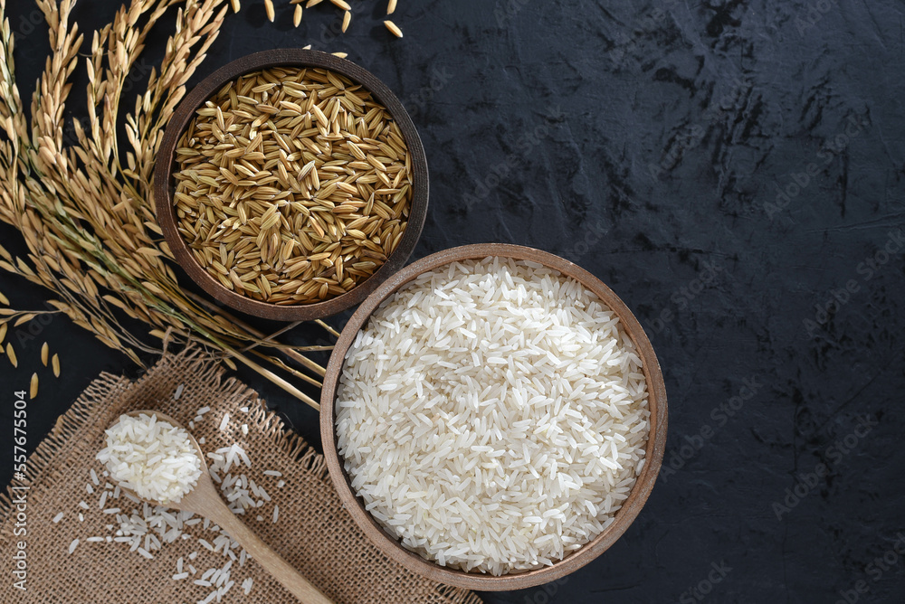 Paddy and rice in baskets placed on a black background with ears of rice.