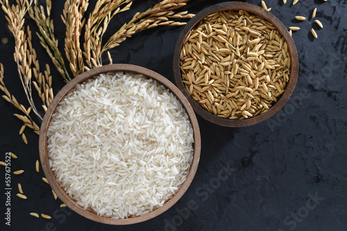 Obraz na płótnie Paddy and rice in baskets placed on a black background with ears of rice. w salonie
