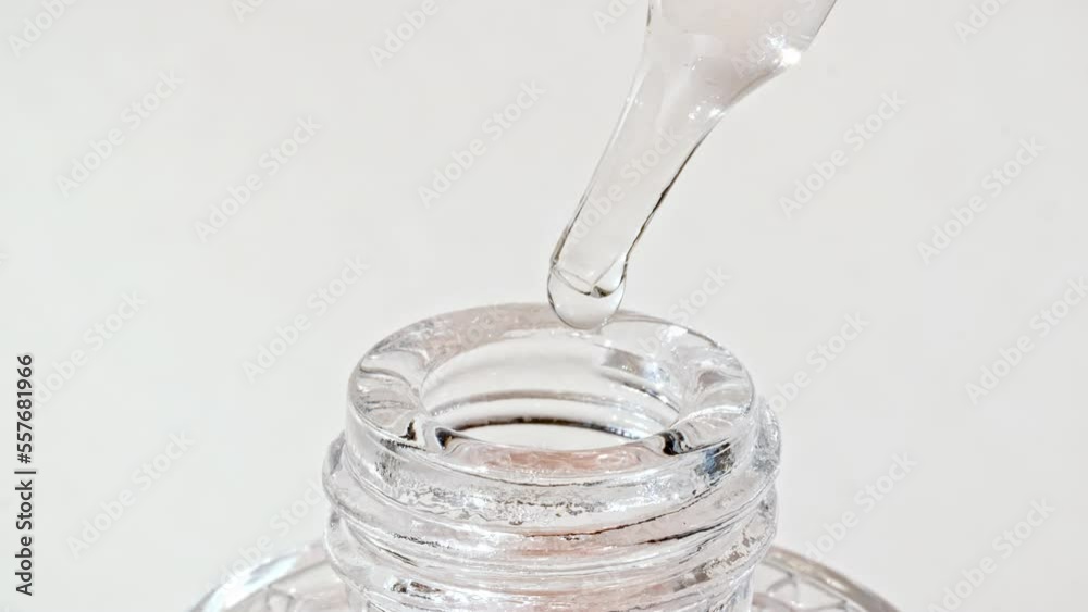 Transparent cosmetic gel fluid with bubbles in pipette dripping into the bottle. Natural Organic Cosmetics, Medicine. Production Close-up. Slow Motion. High quality 4k footage