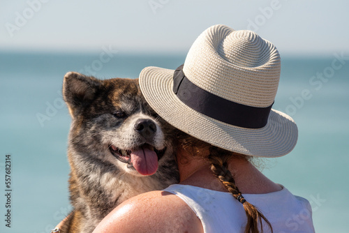 portrait duo, maitresse /akita, chien heureux en vacance de bord de mer Fototapet