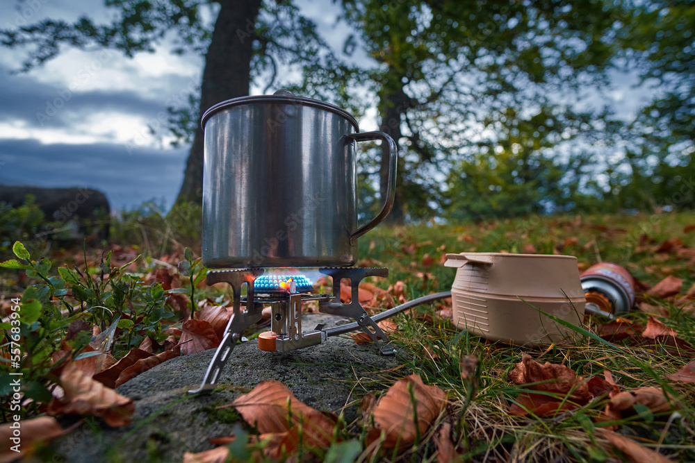 Cooking on a gas burner on a hike. Tourists' morning tea will be ready soon Cooking on a gas burner on a hike. Tourists' morning tea will be ready soon