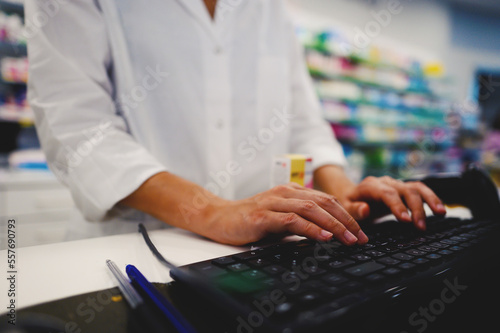 Bild auf Leinwand Pharmacist woman works at computer at the pharmacy counter