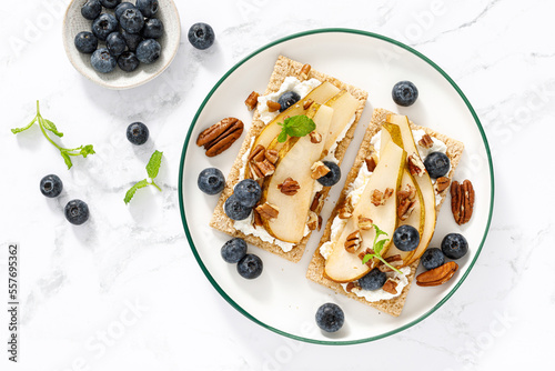 Photos Crispbread with cream cheese, sweet pears, blueberry and pecan nuts