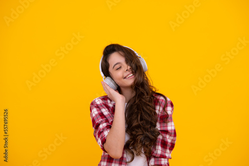 Child listening music with headphones. Girl listening songs via wireless earphones. Headset device accessory. Stylish teenage girl listening to music.