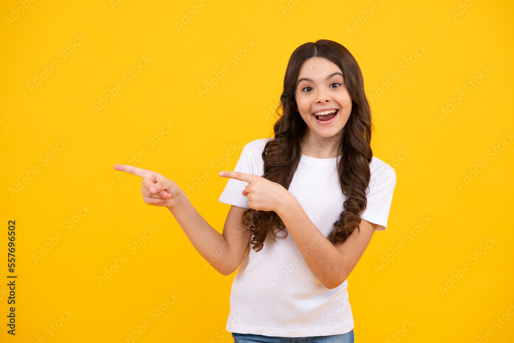 Amazed teenager. Positive teenager child points aside with cheerful expression, shows amazing at blank empty space. Advertisement and mockup. Excited teen girl. Amazed teenager. Positive teenager child points aside with cheerful expression, shows amazing at blank empty space. Advertisement and mockup. Excited teen girl.
