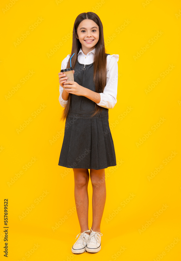 Teenager child with coffee cup isolated on yellow studio background. Girl drinking take away beverage. Teenager child with coffee cup isolated on yellow studio background. Girl drinking take away beverage.