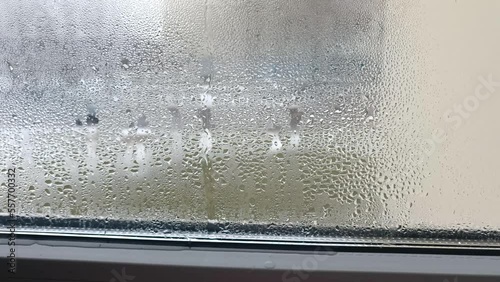 condensation on the window forms droplets flowing on the glass