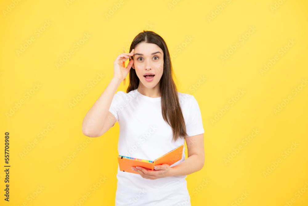 Portrait of student woman. College or high school ducation. Serious young woman with notebooks at camera on yellow studio background. Young female university student. Portrait of student woman. College or high school ducation. Serious young woman with notebooks at camera on yellow studio background. Young female university student.