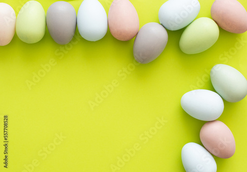 Colorful quail eggs on a light yellow background - an Easter composition. Background for greeting cards  invitations  greetings.