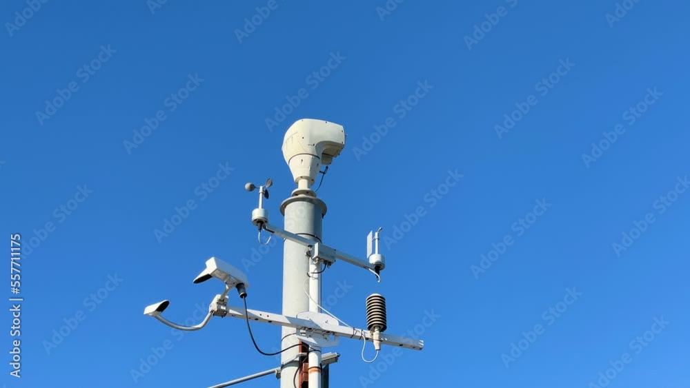 Weather monitoring system and video cameras for observation. Automatic weather station, against the background of blue sky clouds