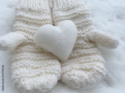 Knitted mittens with heart of snow. 