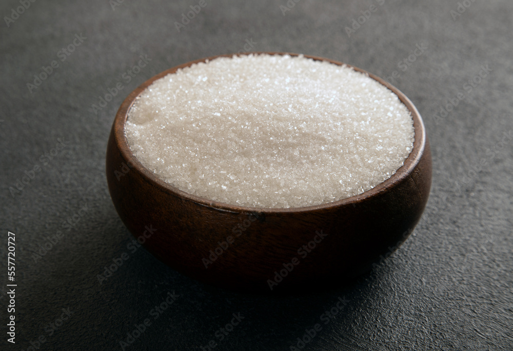 Granulated sugar in bowl on dark background
Granulated sugar in bowl on dark background