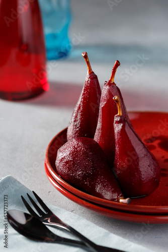 Red wine poached pears in spicy red wine syrup in the red plates