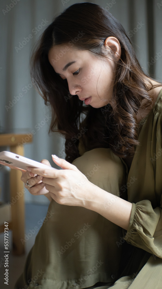 the photo of a caucasian woman holding and typing on her smartphone 