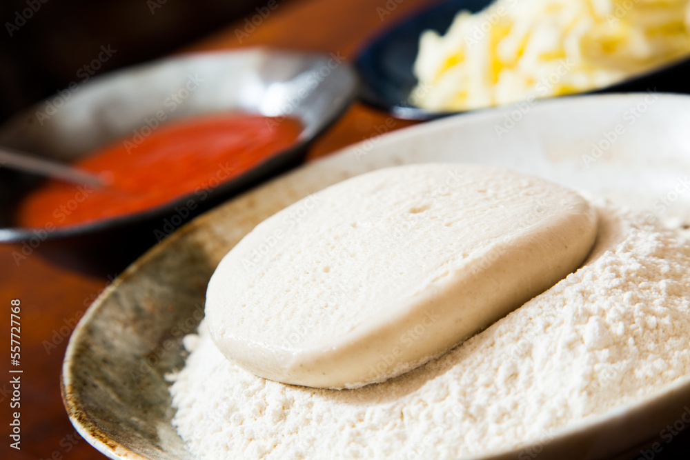 Preparing the dough for a Neapolitan pizza with tomato and cheese. Preparing the dough for a Neapolitan pizza with tomato and cheese.