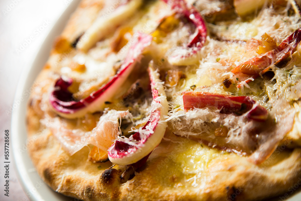 Neapolitan pizza with guanciale, pecorino and radicchio. Classic Italian recipe. Guanciale is an Italian non-smoked cured meat prepared with pork cheeks or cheeks. Neapolitan pizza with guanciale, pecorino and radicchio. Classic Italian recipe. Guanciale is an Italian non-smoked cured meat prepared with pork cheeks or cheeks.