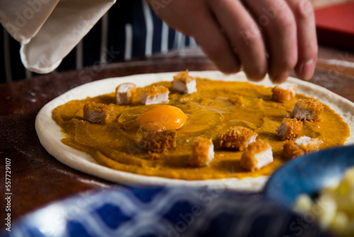 Pizza with breaded pork, curry and egg. Neapolitan pizza made with mozzarella. Italian recipe.