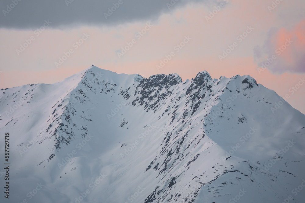 Isolated mountain top with slightly pink skies in the background at sunset