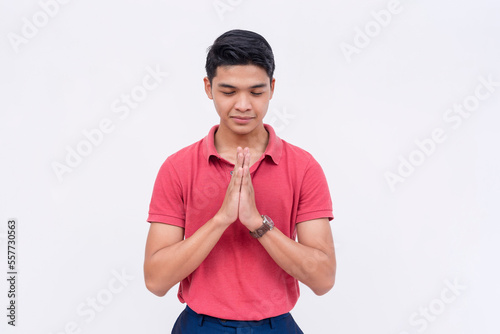 A pious man prays and give thanks to God while closing his eyes. Isolated on a white backdrop.