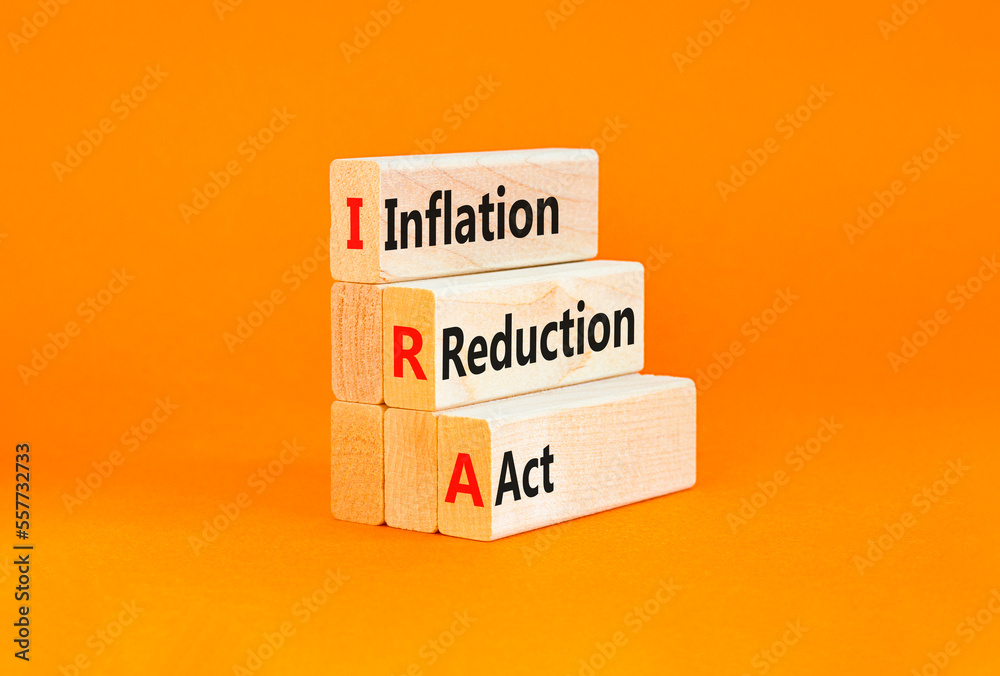 Naklejka premium IRA inflation reduction act symbol. Concept words IRA inflation reduction act on wooden blocks on a beautiful orange table orange background. Business IRA inflation reduction act concept. Copy space.