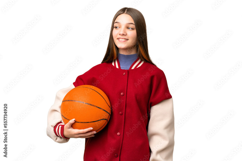 Teenager girl playing basketball over isolated chroma key background looking to the side and smiling