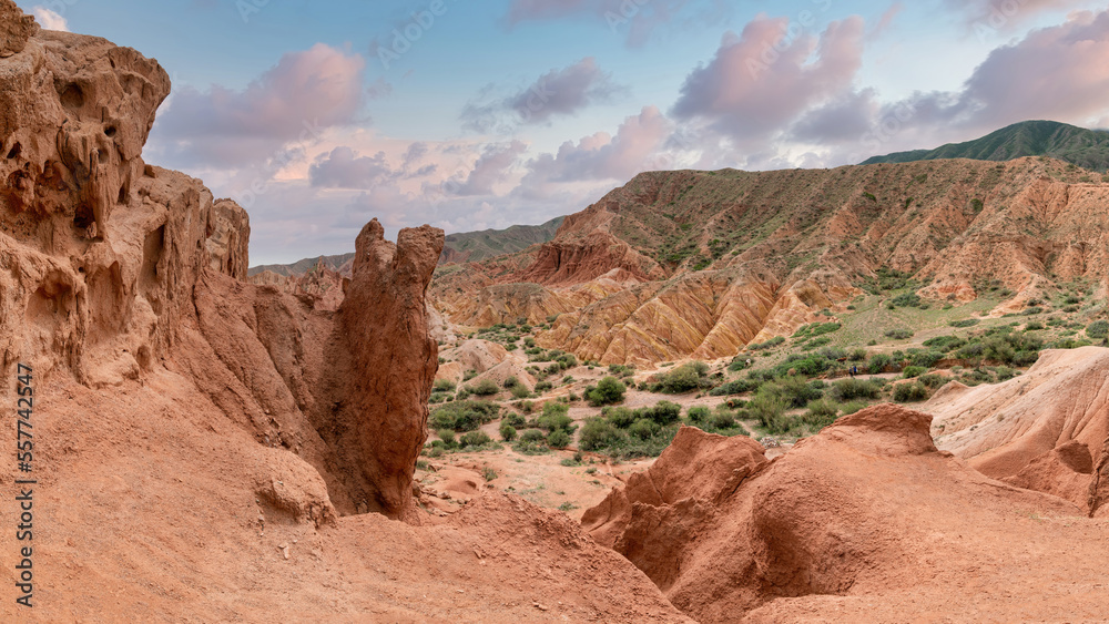 Fototapeta premium Scenery from Fairytale Canyon, unique rock formation located in Kyrgyzstan. Canyon is known for its unusual and colorful rock formations, which have been shaped over time by wind and water erosion.
