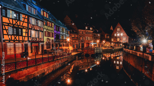 Traditional Alsatian houses in old town of Colmar, decorated and illuminated at snowy christmas night, Alsace, France