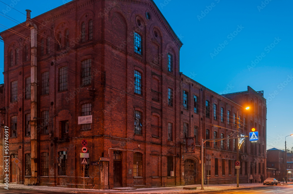 Fototapeta premium Old abandoned haunted red brick factory of stockings, pantyhose and socks in Central Europe, Poland