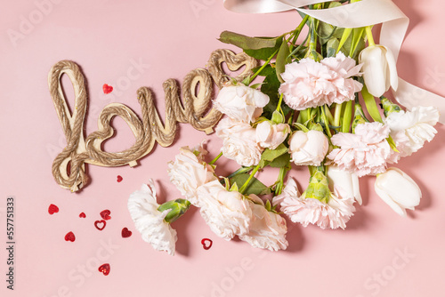Valentine's Day background with love letters and beautiful spring flowers on light pink background. Valentine's day, Womans day, mothers day greeting card. View from above.