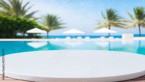 Empty ceramic mosaic table top and blurred swimming pool in tropical resort in summer banner background, for display or montage your products