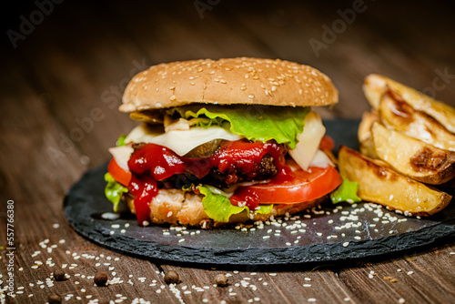 Burger  hamburger with french fries  ketchup  and fresh vegetables on stone board. Homemade cooking