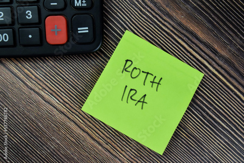 Concept of ROTH IRA write on sticky notes isolated on Wooden Table. photo