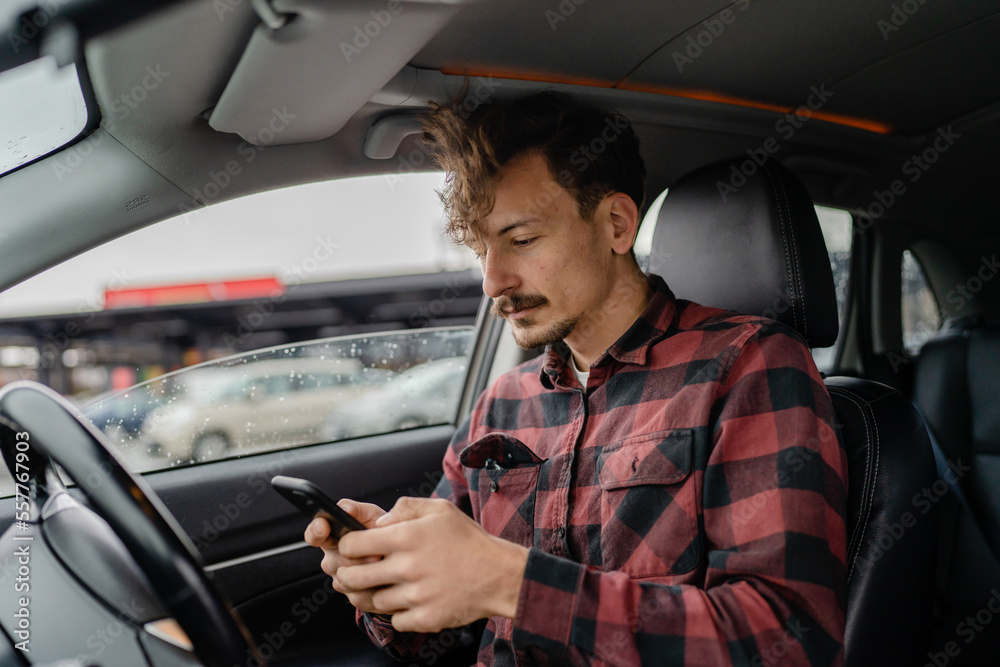 one adult man caucasian with mustaches sit in car use mobile phone