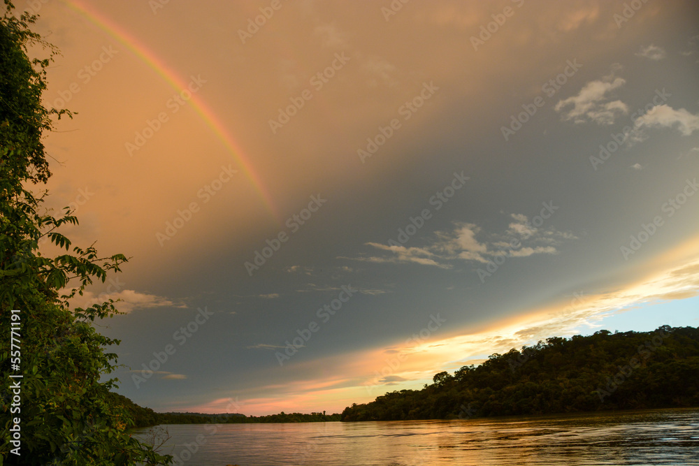 Beautiful rainbow in moody evening sky over Amazon River contributory Teles Pires, Matto Grosso, Brazil Beautiful rainbow in moody evening sky over Amazon River contributory Teles Pires, Matto Grosso, Brazil