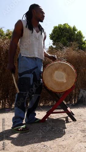 Vertical video of Medium shot of black men playing dundun one standing and one sitting photo