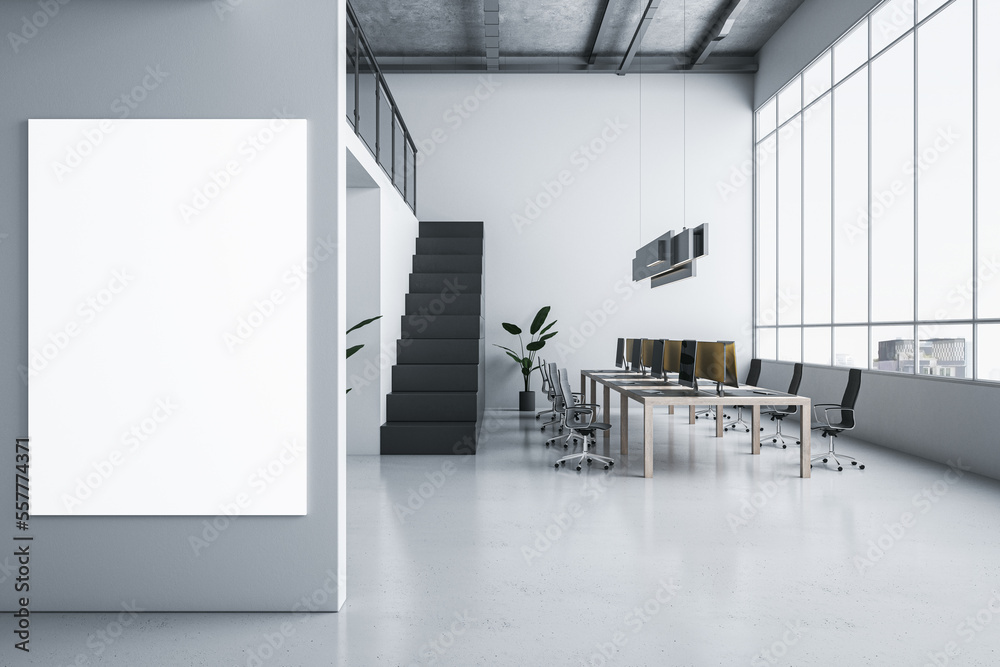 Fototapeta premium Front view on blank white poster on light grey wall in spacious coworking office with wooden table, light floor, dark stairway and city view background from window. 3D rendering, mock up