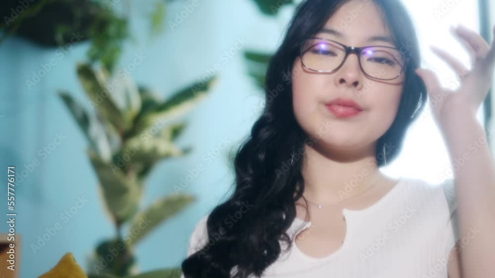 Portrait of charming asian girl with eyeglasses looking at the camera in the light living room at home Beautiful young female indoors Portrait of charming asian girl with eyeglasses looking at the camera in the light living room at home Beautiful young female indoors