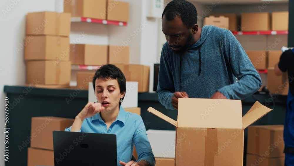 Business partners looking at stock and packaging, working on shipment and delivery. Man and woman checking quality of merchandise order at warehouse, retail wholesale supply chain. Business partners looking at stock and packaging, working on shipment and delivery. Man and woman checking quality of merchandise order at warehouse, retail wholesale supply chain.