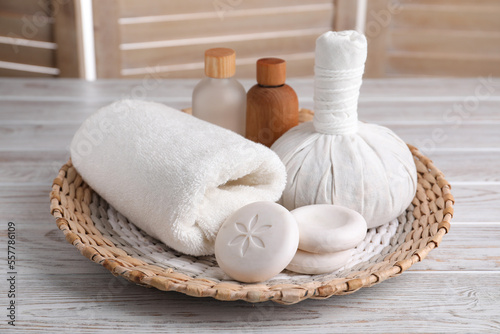 Spa composition with skin care products and wicker basket on white wooden table