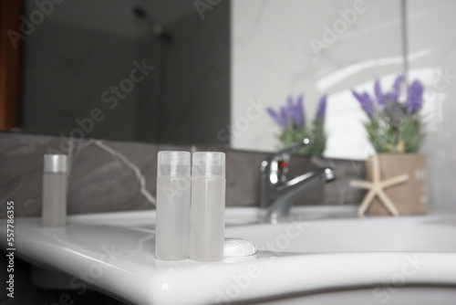 Bottles of shower gel on sink in bathroom. Space for text