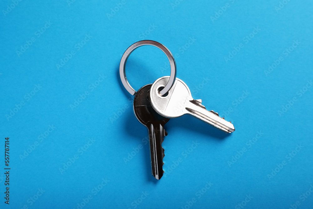 House keys on light blue background, top view. Real estate agent services House keys on light blue background, top view. Real estate agent services