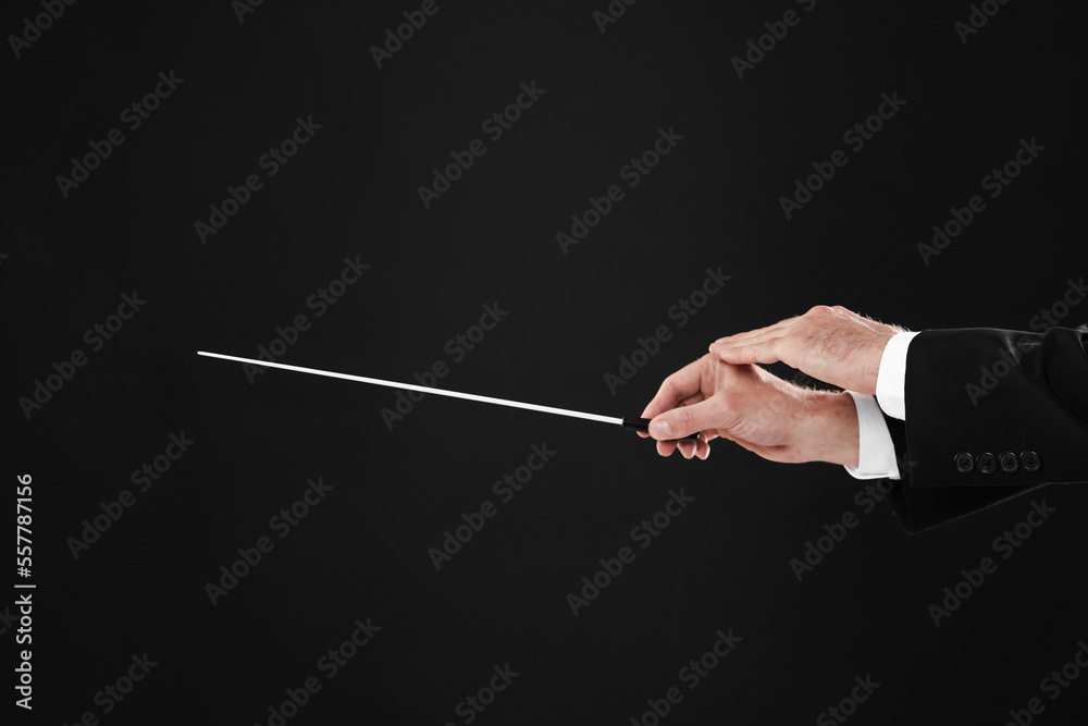 Professional conductor with baton on black background, closeup Professional conductor with baton on black background, closeup