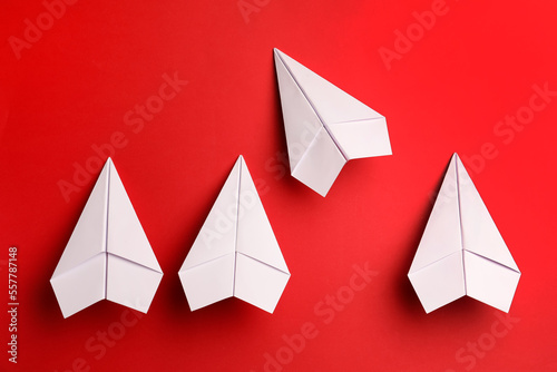 Flat lay composition with paper planes on red background