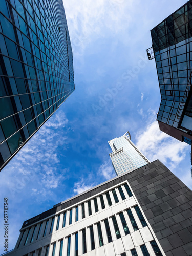 Low angle view of tall skyscrapers in modern financial city center - clear blue sky background